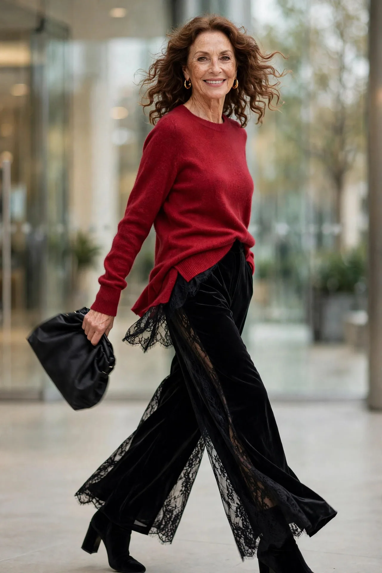 Ruby Cashmere Glow — A ruby-red cashmere crew-neck sweater half-tucked into black velvet wide-leg trousers, with black velvet block-heel ankle boots.