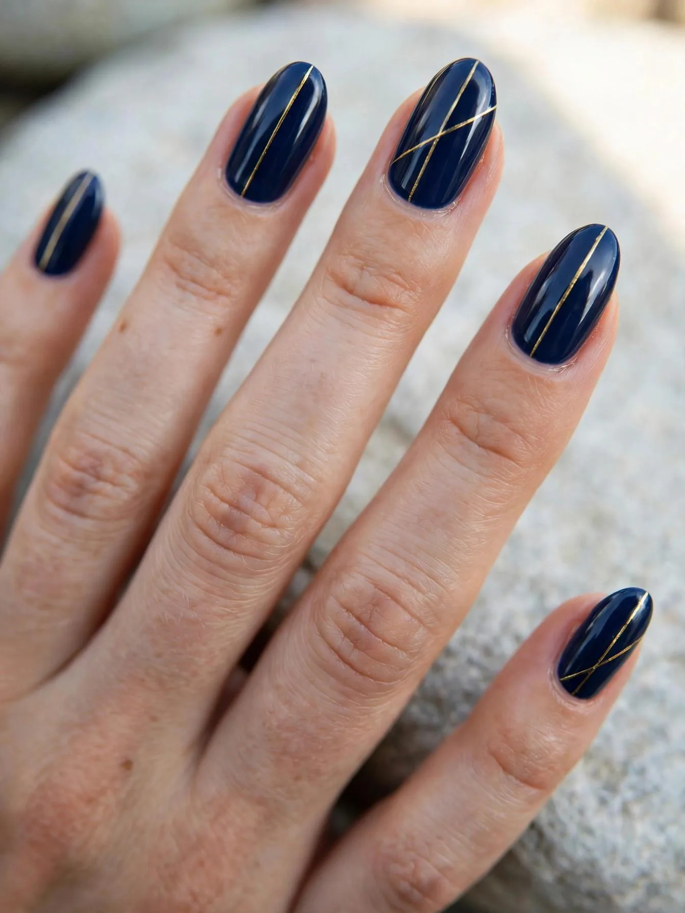Medium nails in glossy navy blue with one thin gold line per nail.