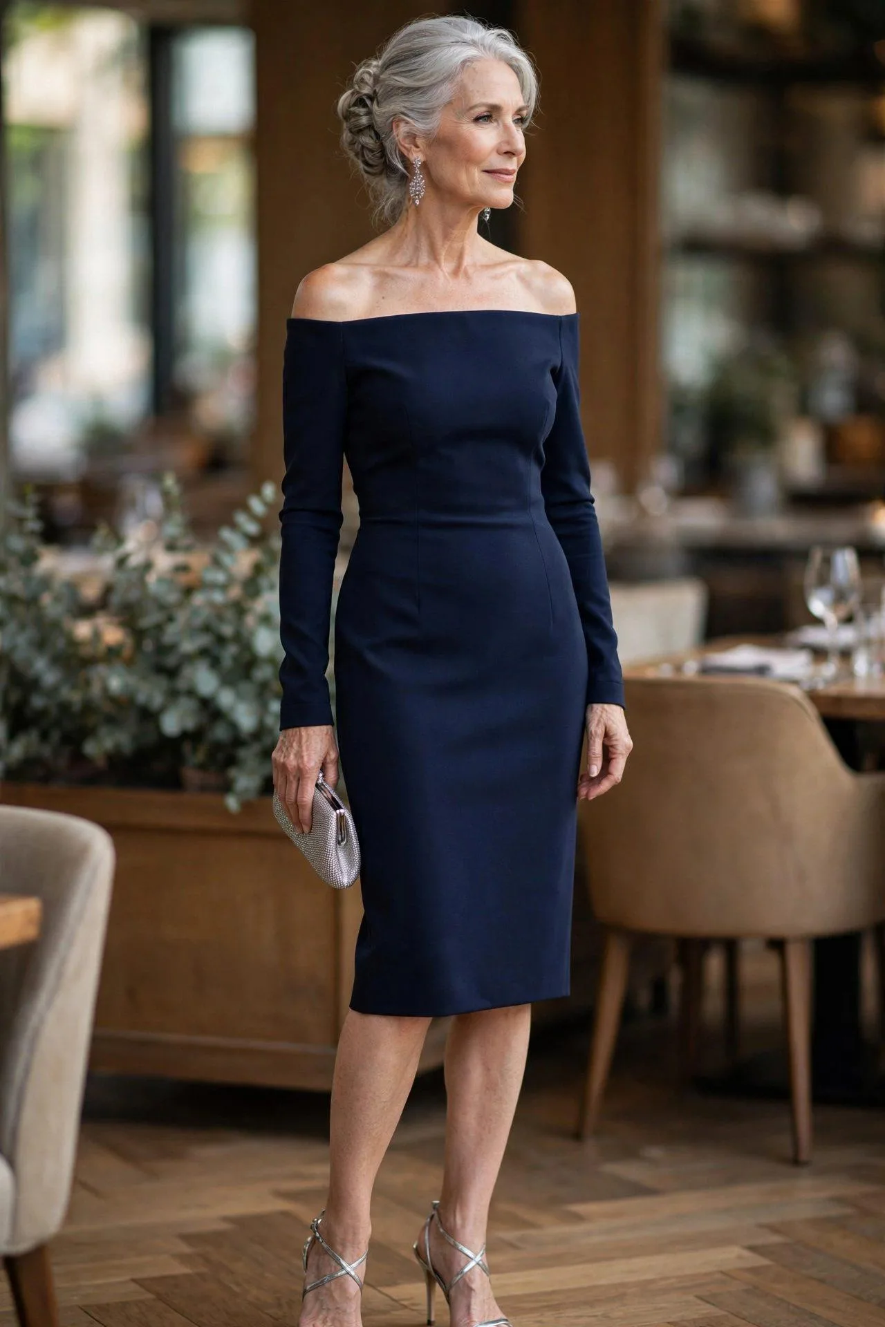 Distinguished woman in a navy off-shoulder sheath dress with sparkling earrings