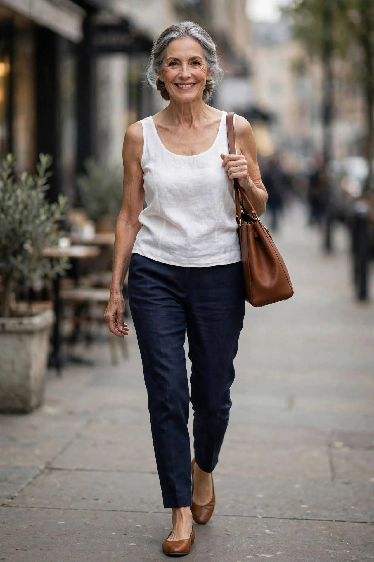 Poised woman over 50 pairing white linen sleeveless top with navy cropped pants