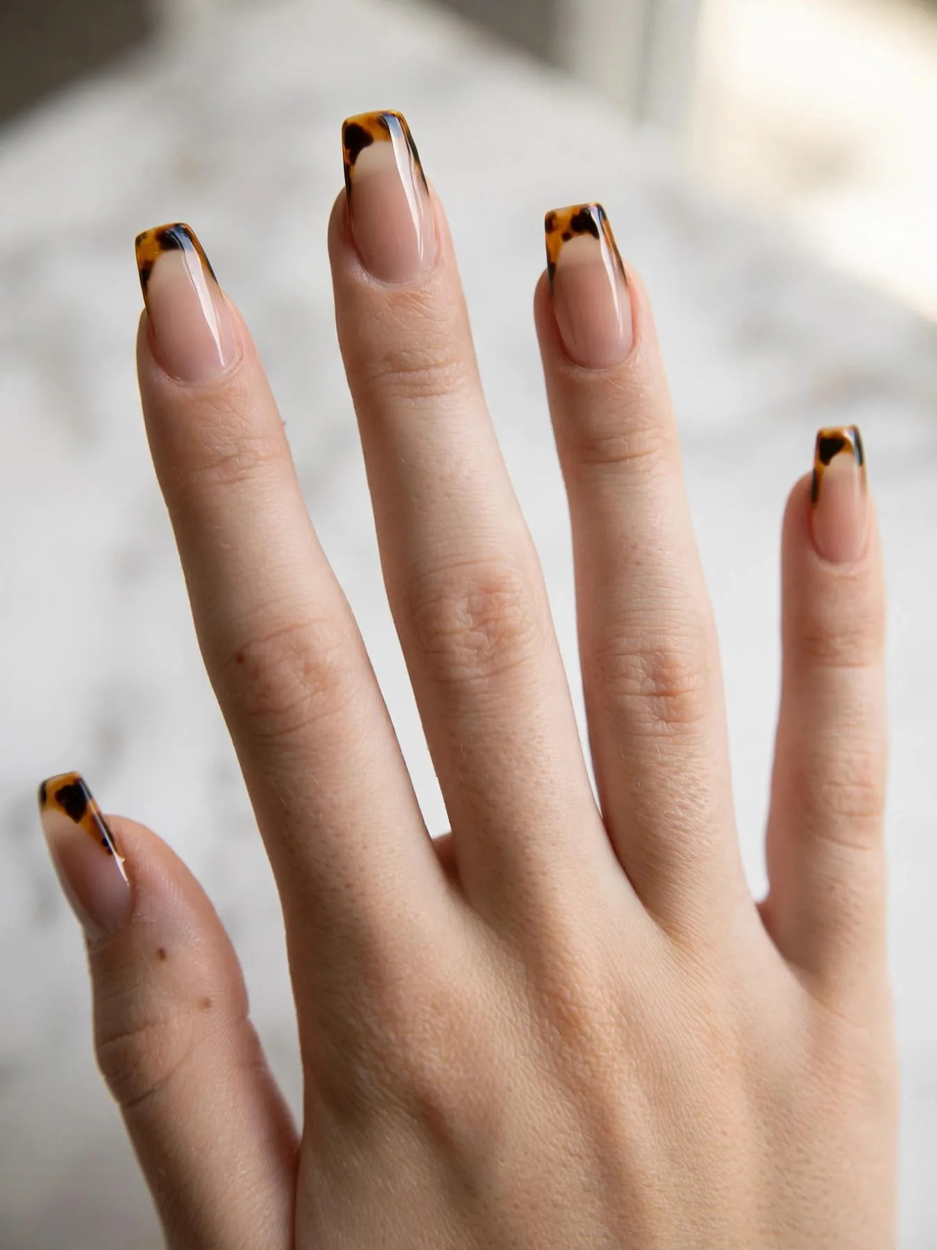 Medium coffin nails with amber tortoiseshell print on French tips.