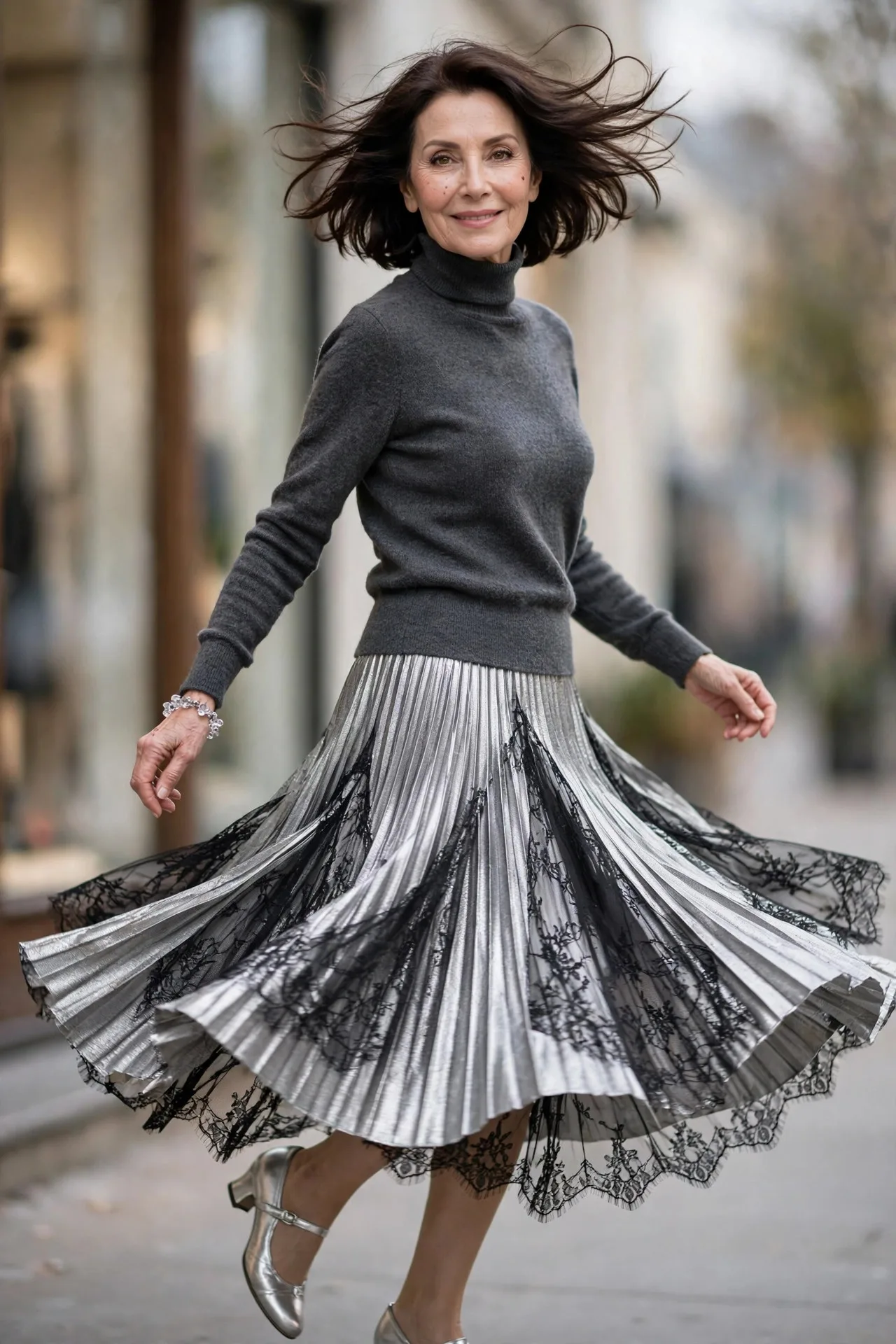 Silver Lame Layers — A silver lamé pleated midi skirt worn with a charcoal-grey fine-knit turtleneck French-tucked in, finished with silver low-heeled Mary Janes.