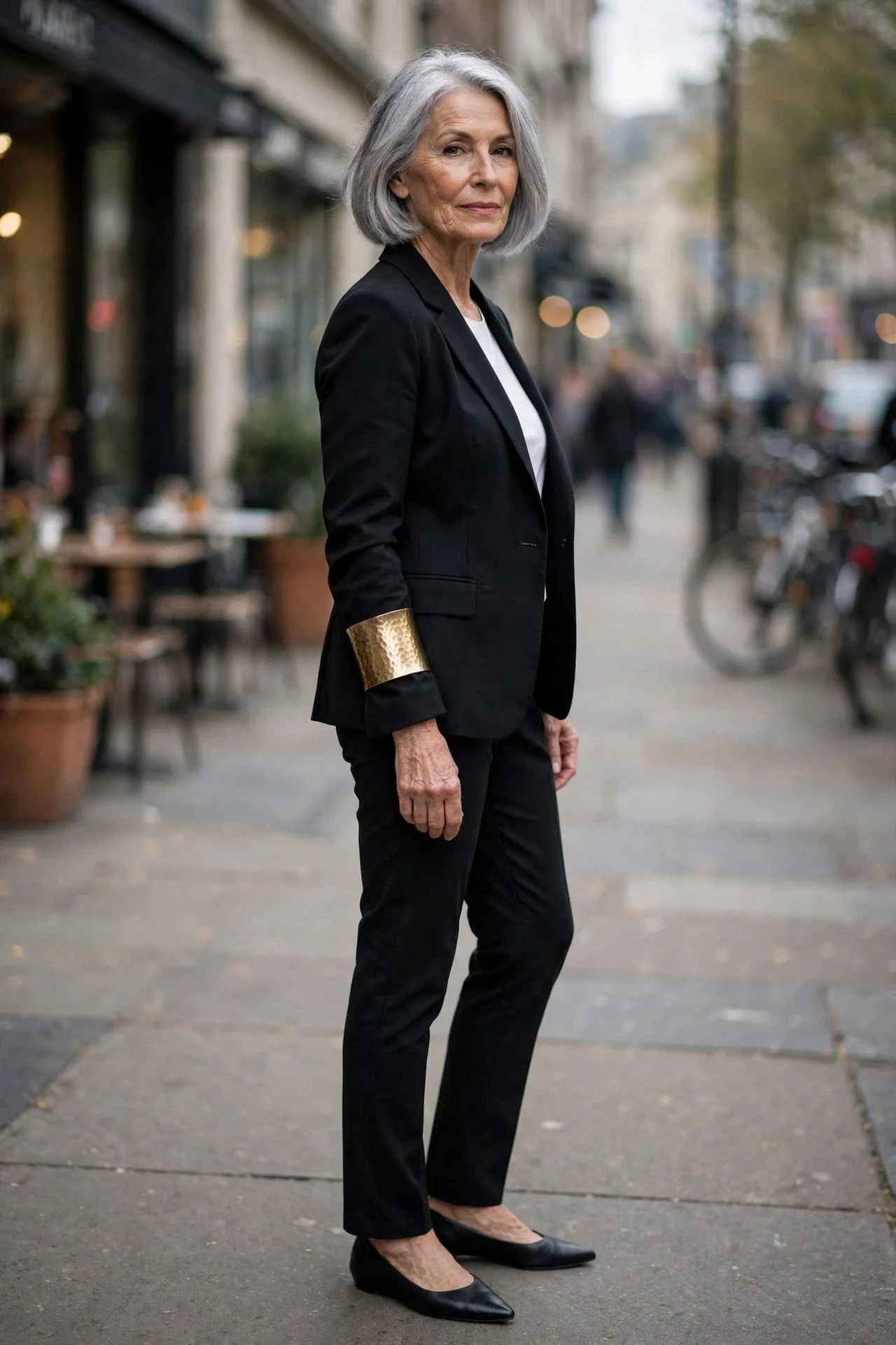 Polished wide cuff slid over a navy blazer sleeve near the wrist.
