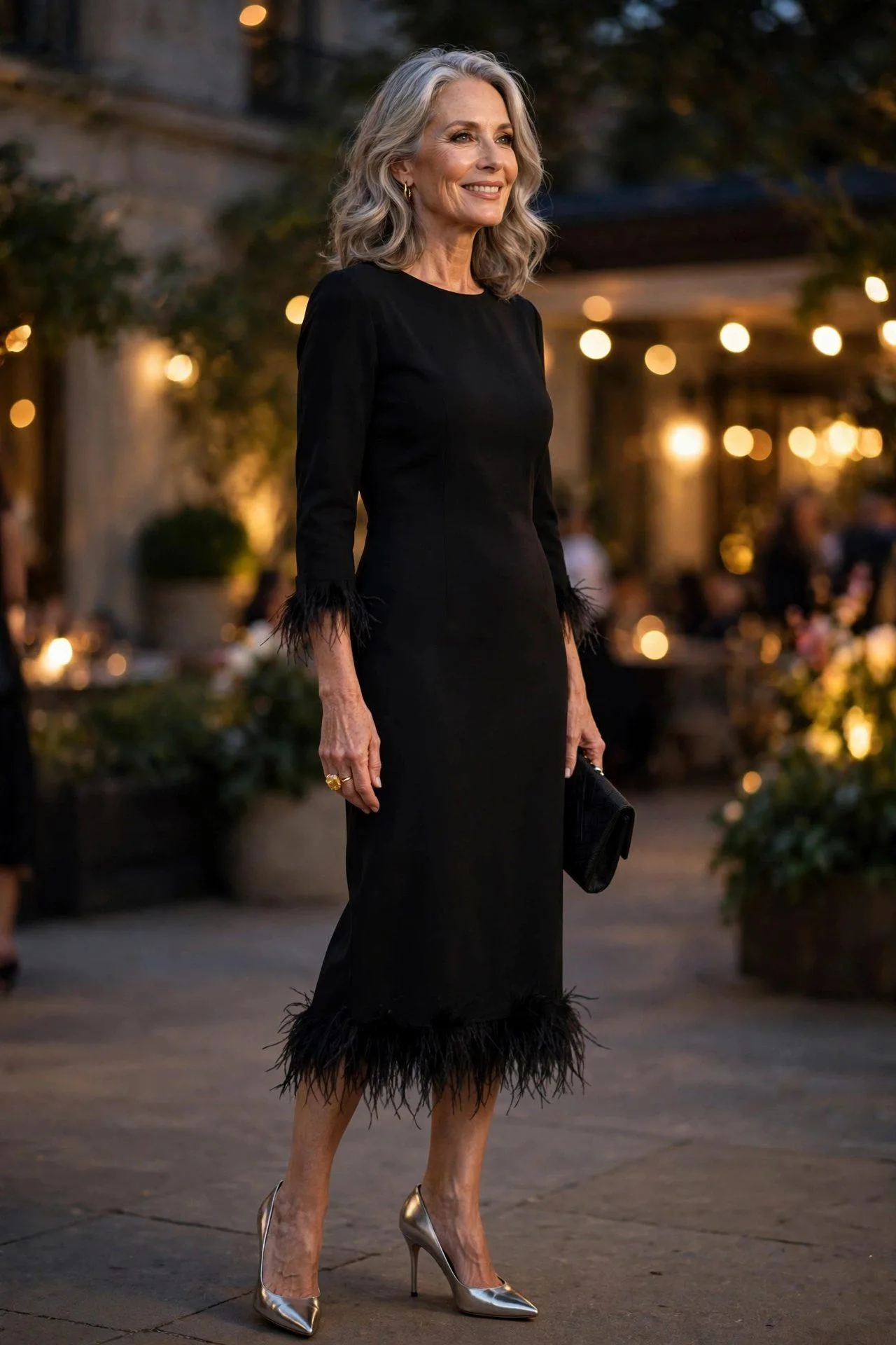 Classic beauty in a feather-trimmed little black dress and metallic silver pumps glowing at an evening soiree.