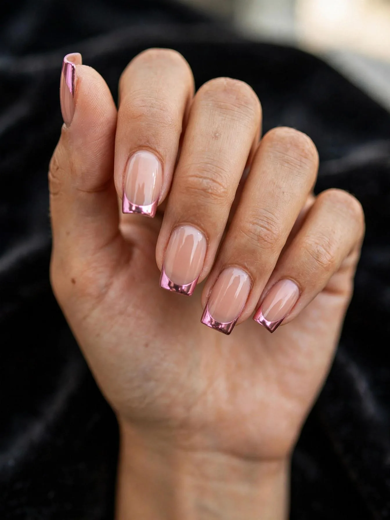 Square nude nails tipped with mirror-finish pink chrome.