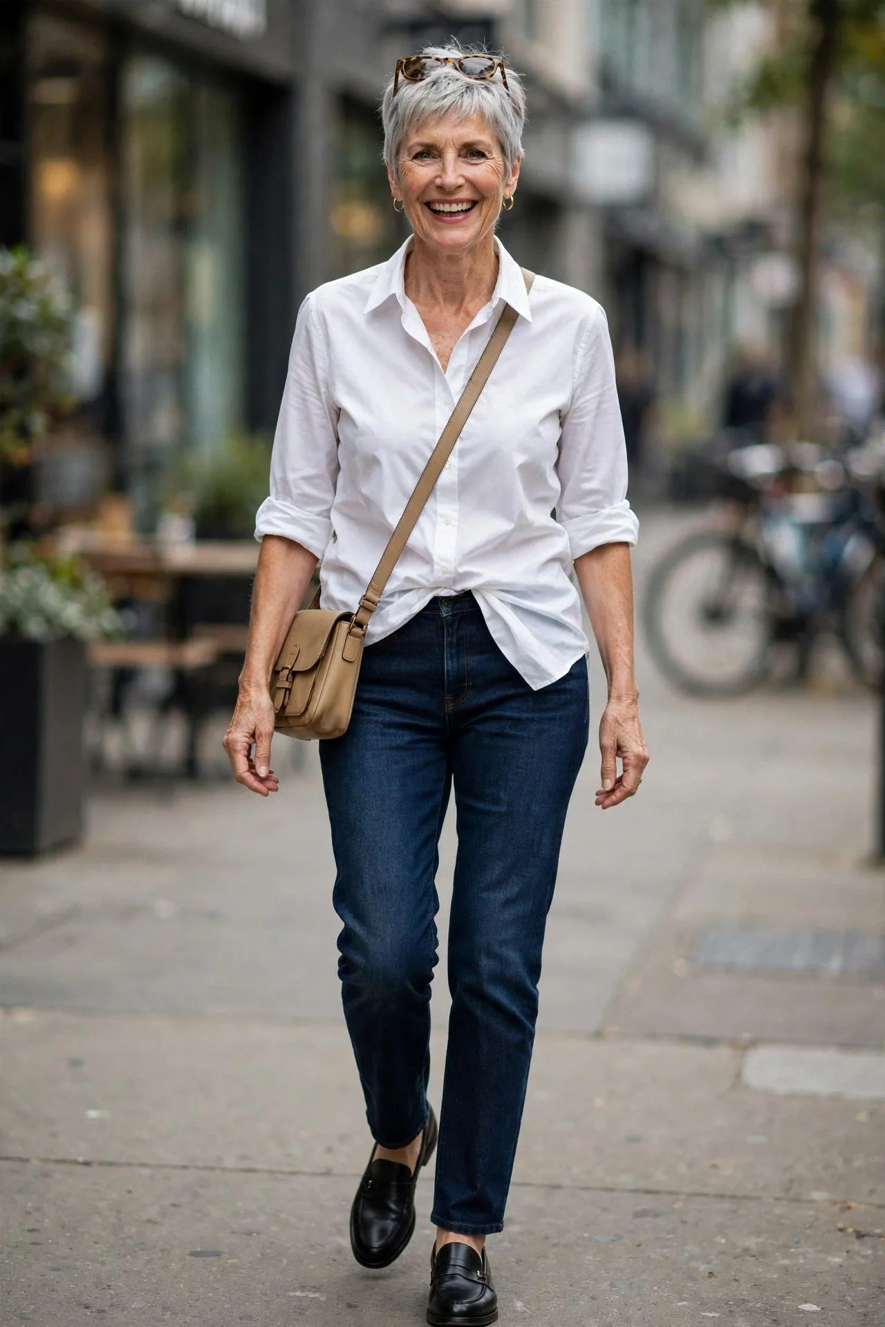 Chic mature lady pairing dark denim jeans with crisp white shirt and loafers