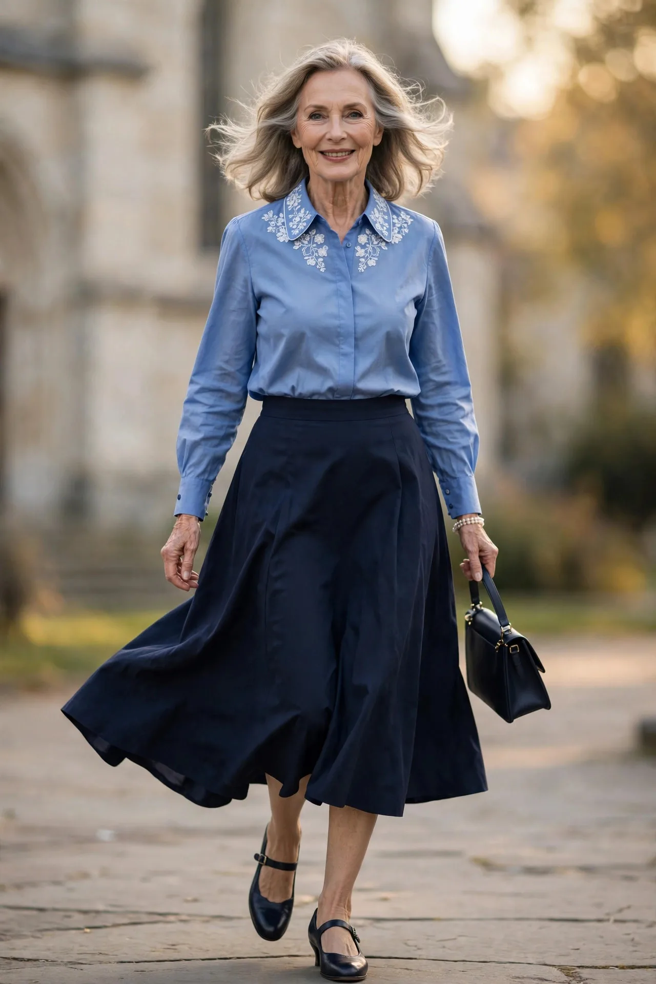 Chapel Pew Blouse — A cornflower-blue cotton poplin blouse with a delicately embroidered collar, tucked into a navy A-line midi skirt.