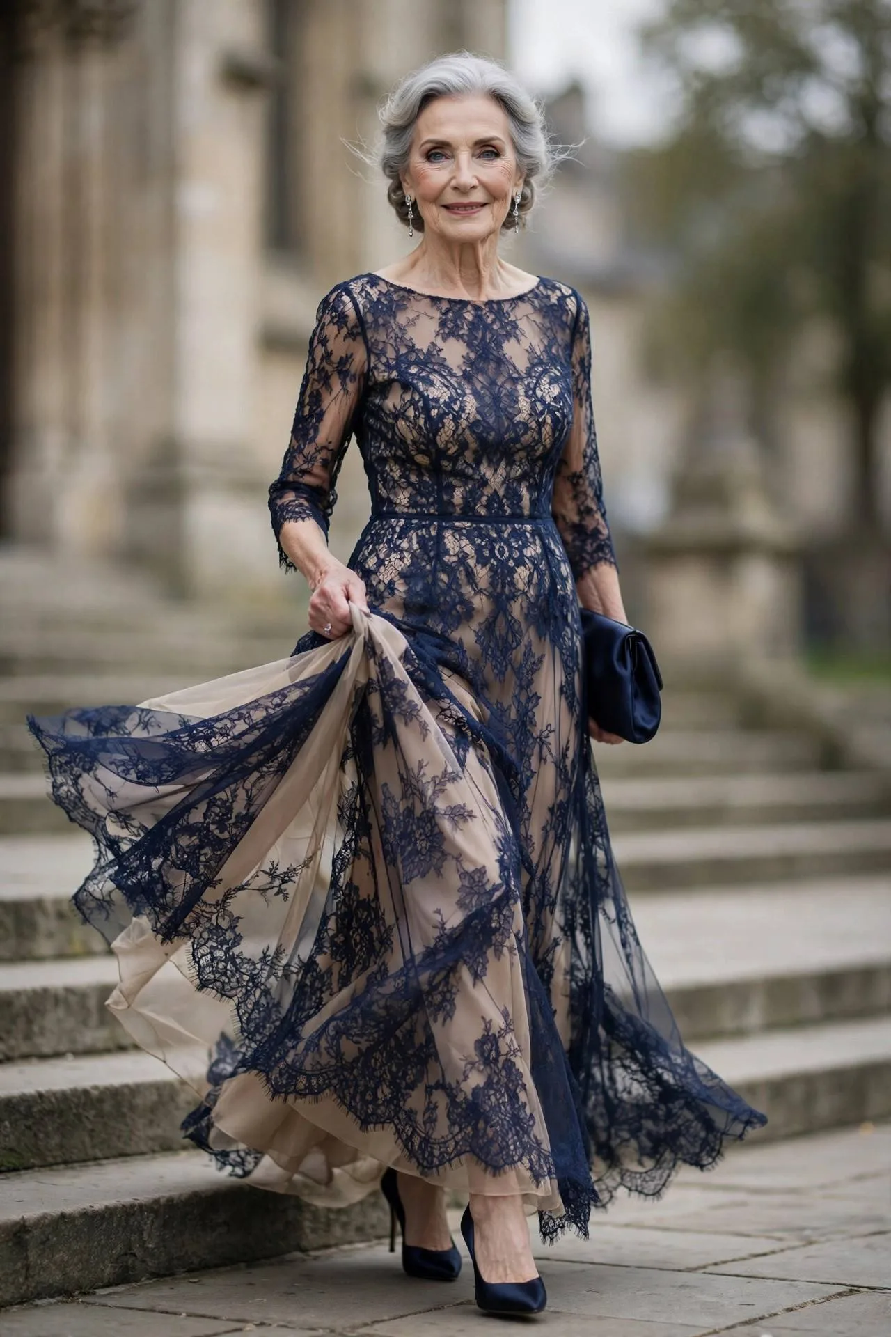 Graceful older woman wearing navy lace overlay gown with silver earrings