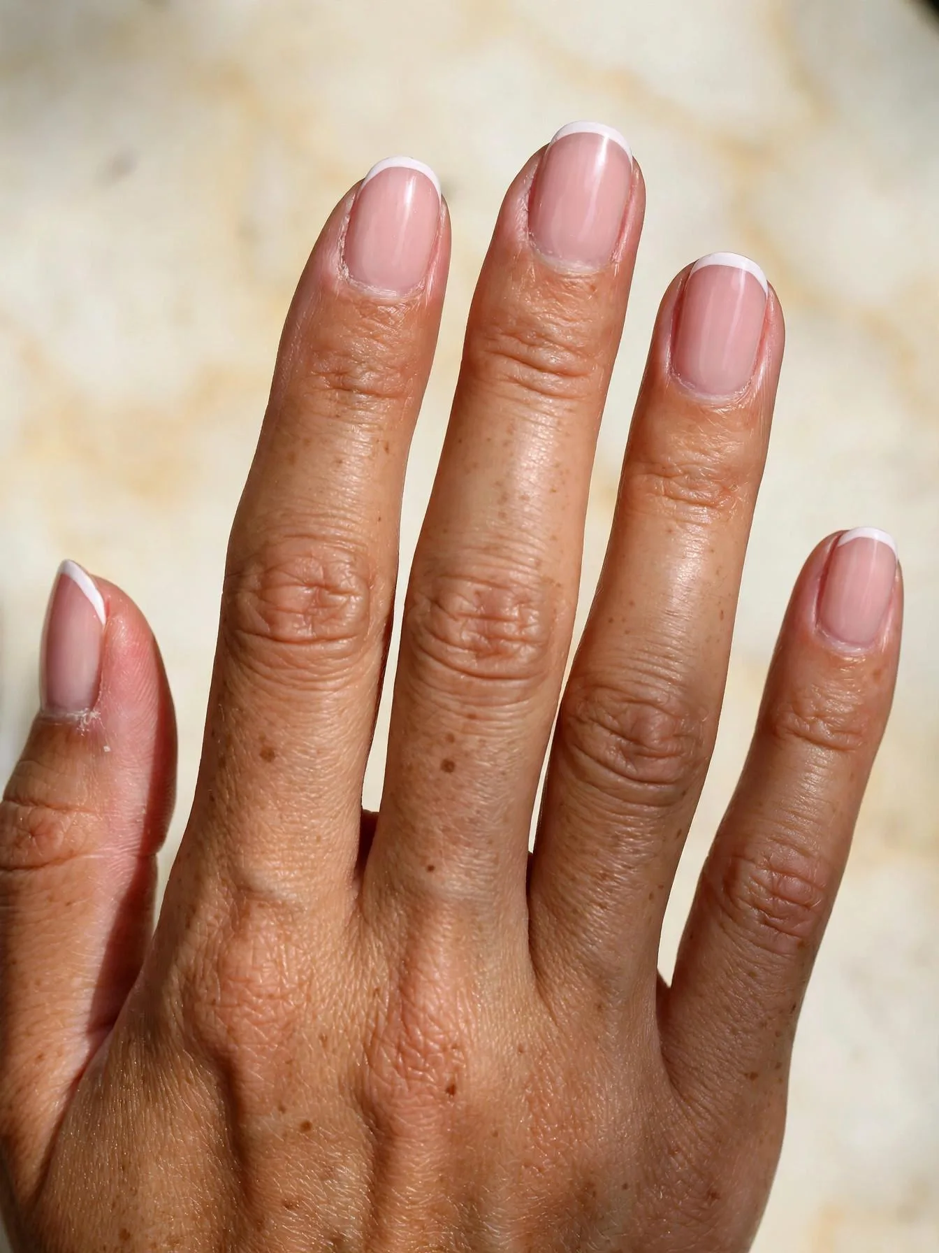 Sheer pink almond nails finished with bright white French tip lines.