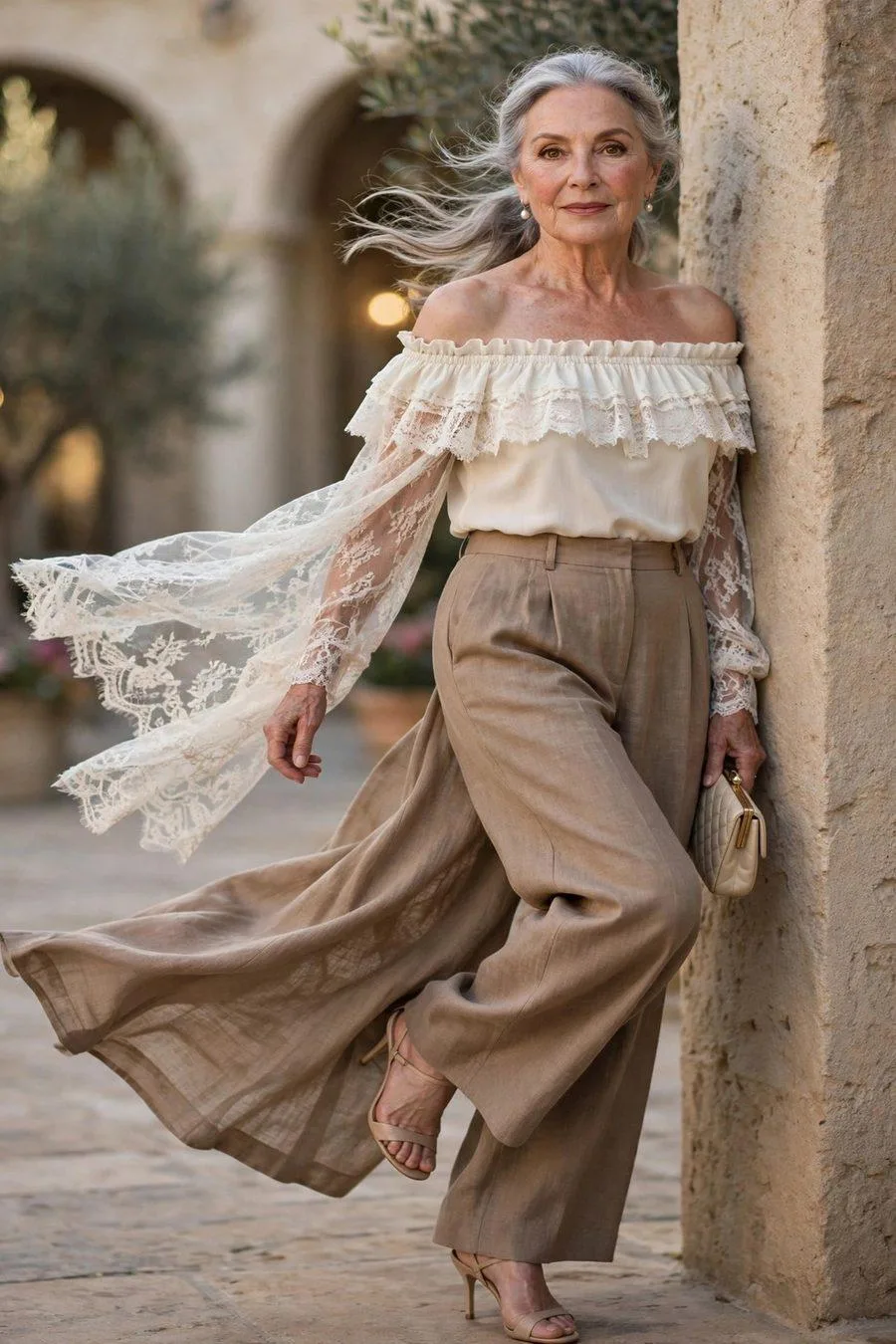 Elegant mature woman in ivory off-shoulder top and taupe trousers dating
