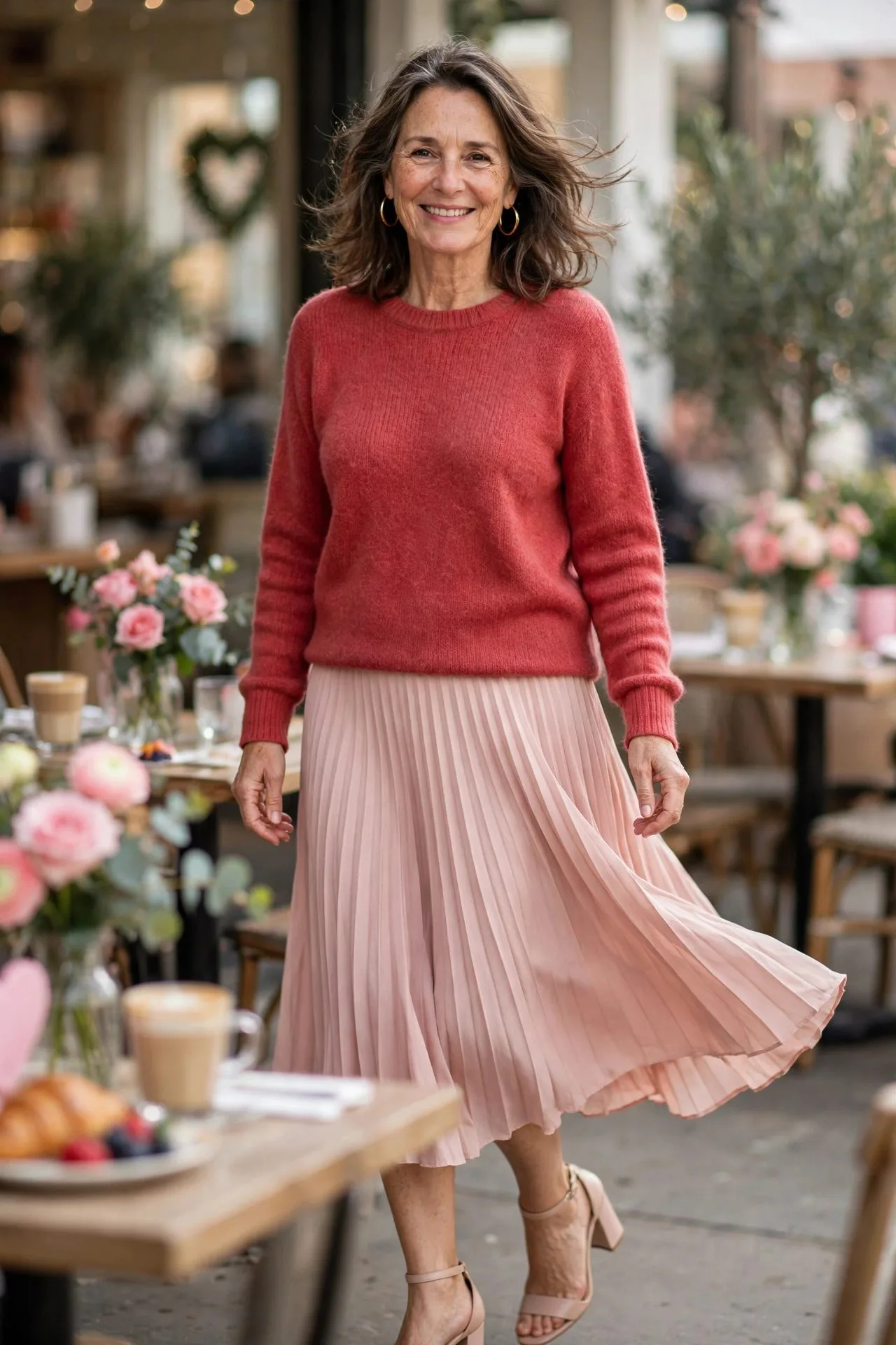 Woman over 50 in red knit sweater and blush pleated skirt