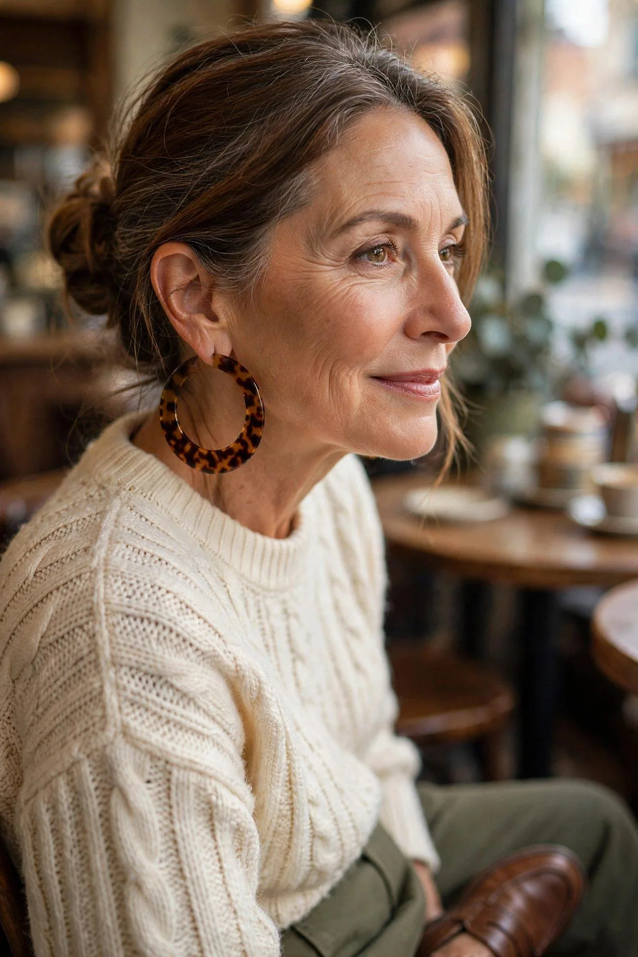 Amber-mottled acetate geometric earrings paired with an olive jacket.